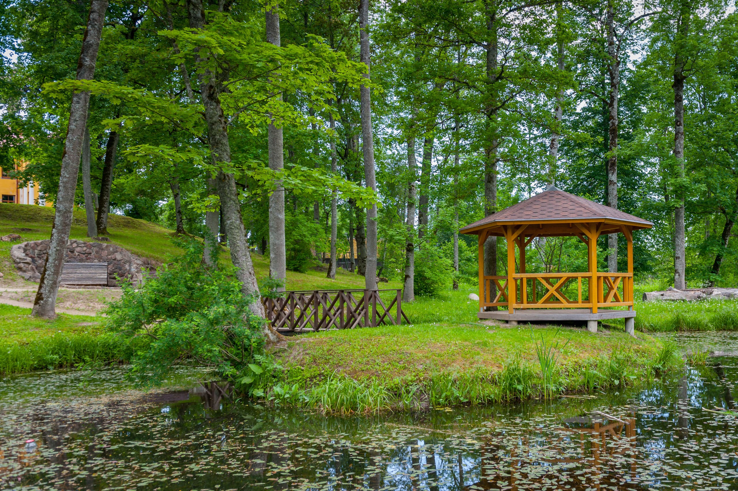 View of pond with small island of Love and wooden gazebo in the castle park. Composite Decking stairs with lights in San Antonio
